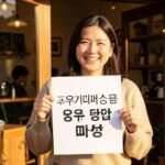 A cheerful small business owner proudly holding up a printed A4 poster with Korean text '고유가피해지원금 사용 가능 매장' in front of a cozy café storefront, warm sunlight, friendly atmosphere, realistic photo style