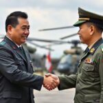 A symbolic handshake between military officials from South Korea and a Southeast Asian country with attack helicopters in the background, representing defense export diplomacy